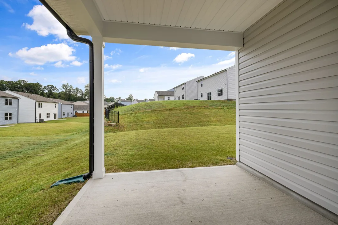 Broom-finished concrete patio beneath a covered residential porch; illustrative stock photo