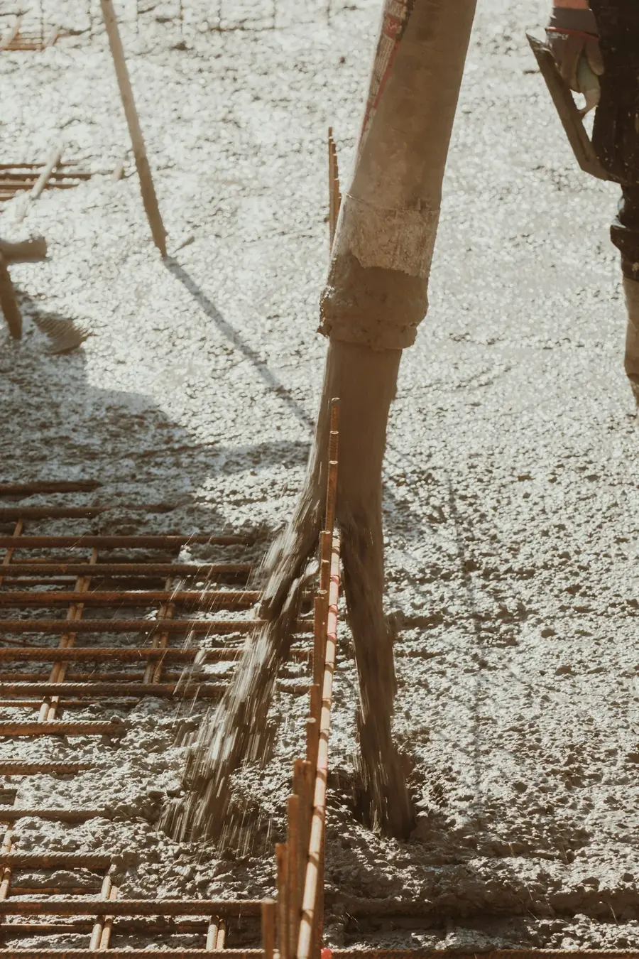 Fresh concrete being placed over steel reinforcement