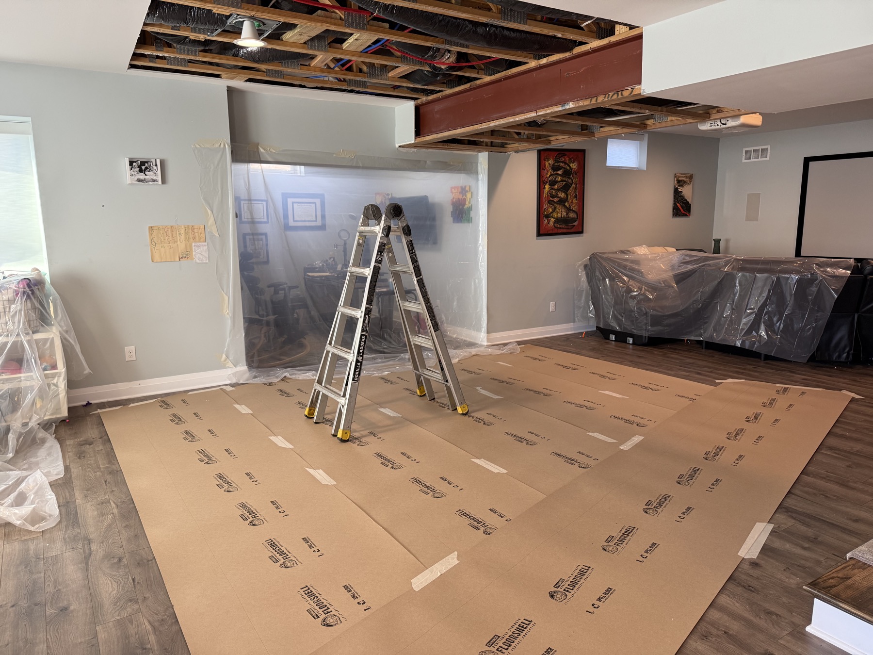 Occupied home with ceiling opened and furnishings protected during renovation