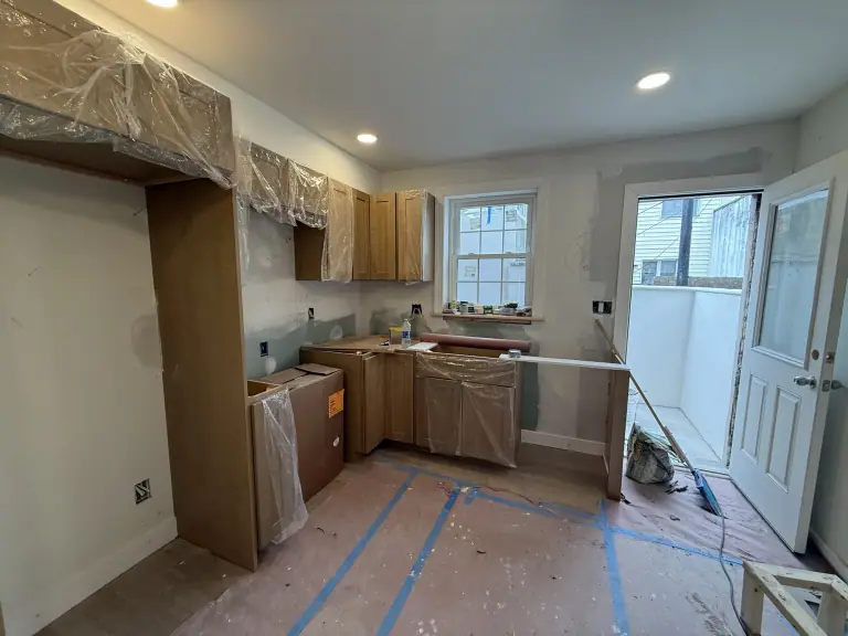 Kitchen cabinetry installation with floor protection in place